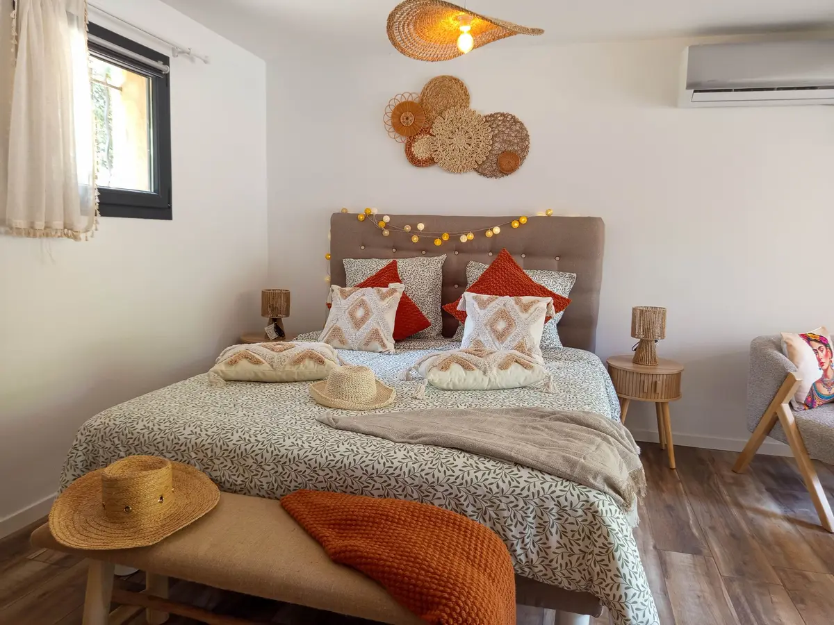 Lit double avec coussins terracotta et déco bohème